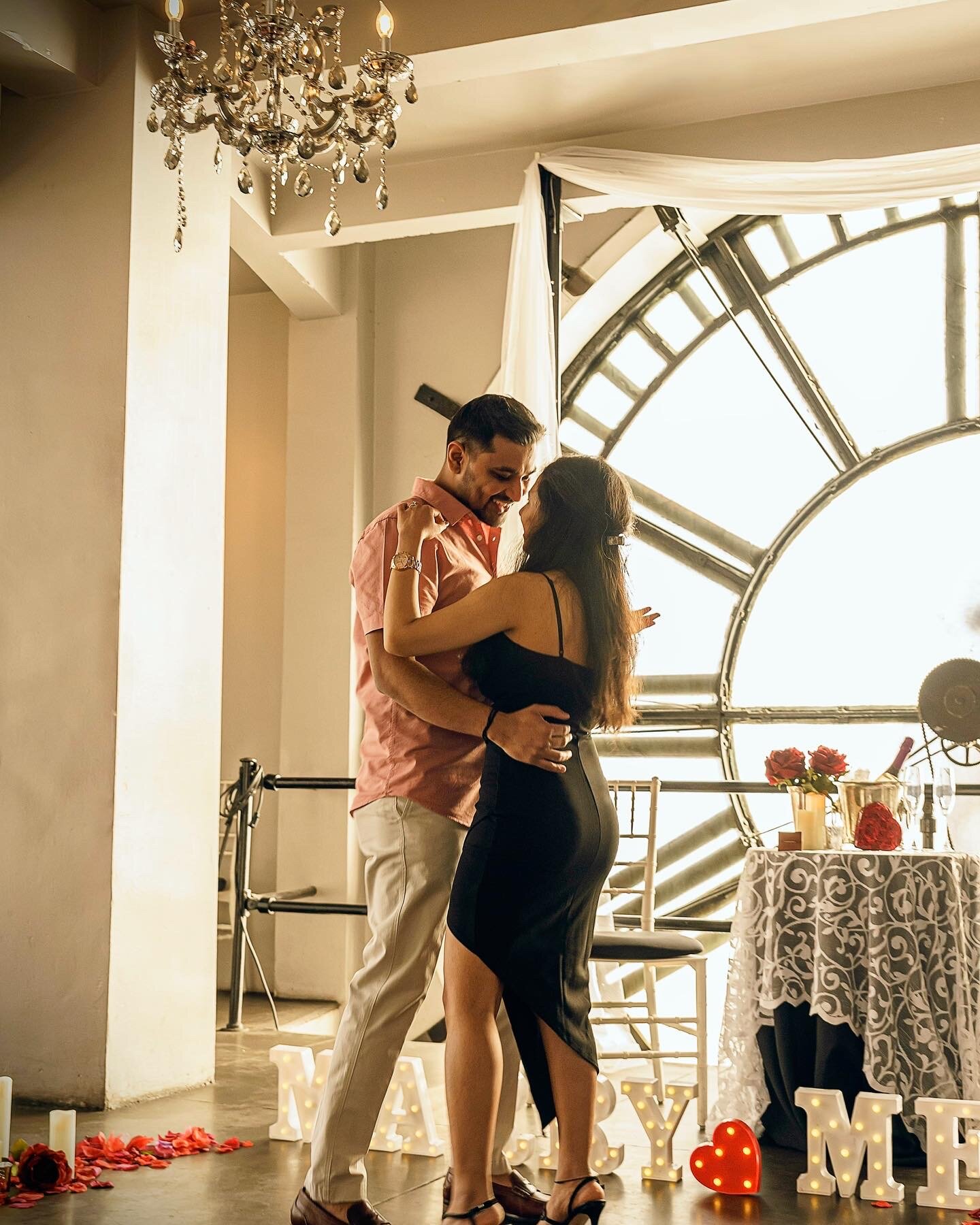 Vividh proposing to his wife under a giant clock tower